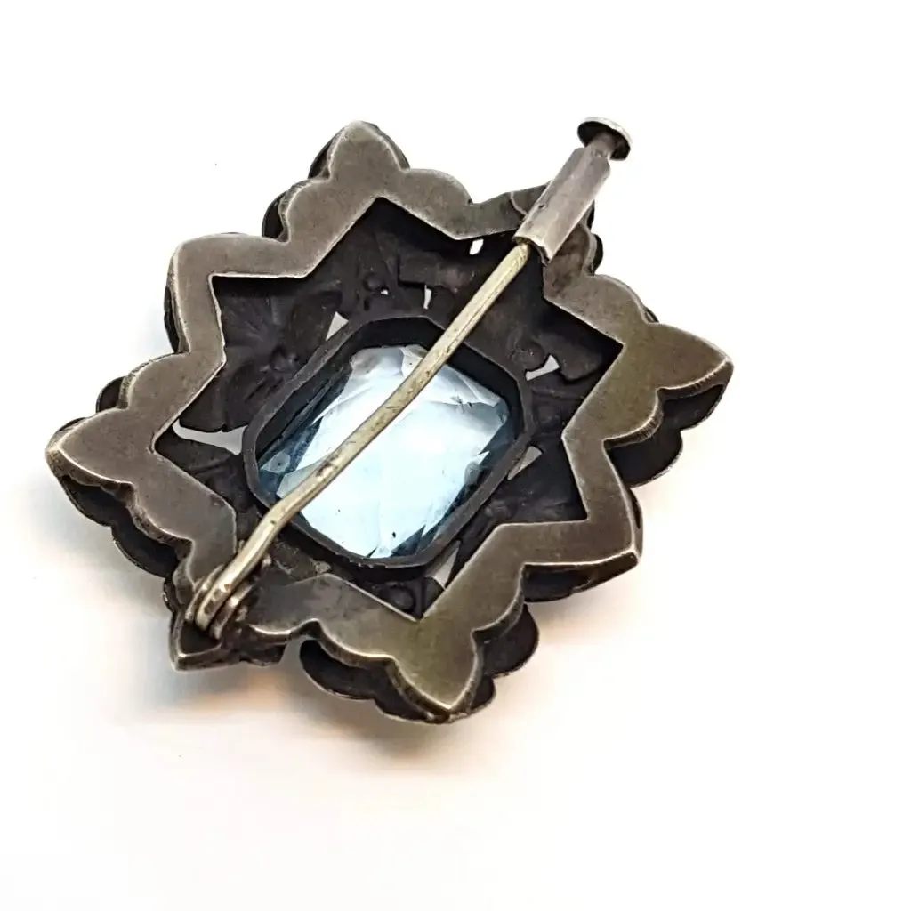 Art deco brooch. Silver pin made of silver, views of gold and simile of aquamarine.